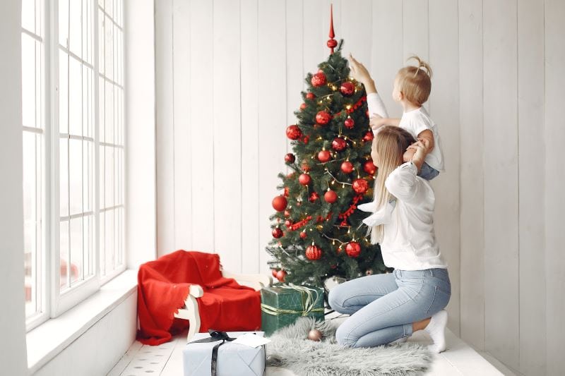 woman-has-fun-preparing-christmas-mother-white-shirt-is-playing-with-her-daughter-family-is-resting-festive-room